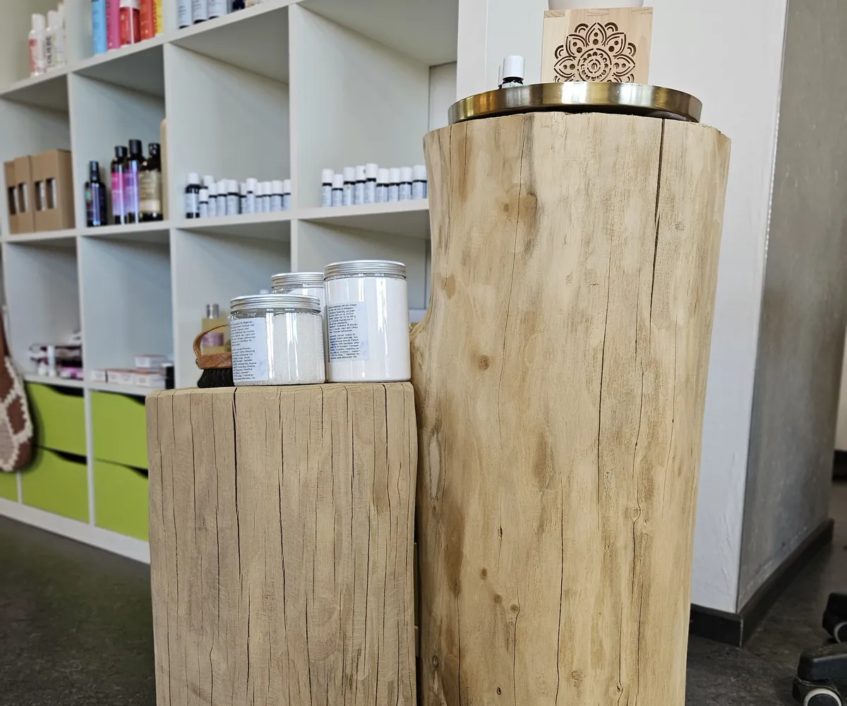 Naturprodukte auf Baumstamm-Podesten vor dem Produktregal