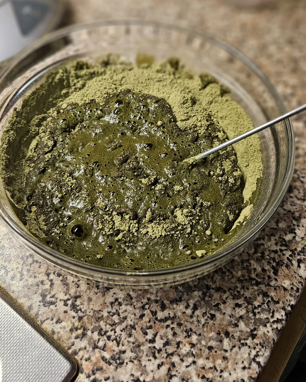 Angerührte Pflanzenfarbe als grüne Paste in einer Glasschale